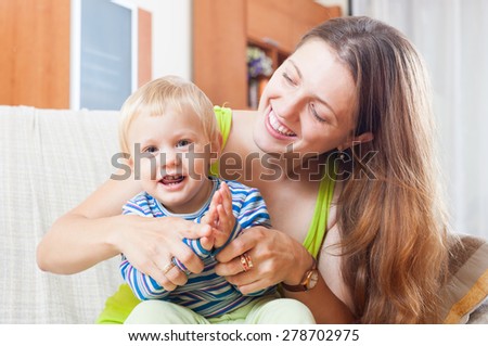Portrait of happy mom with toddler on sofa