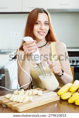 woman  making milk shake with bananas at home kitchen