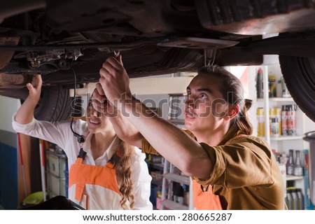 Auto service center crew repairing a broken car