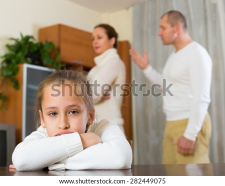 Parents and daughter quarrel in the home. Focus on girl