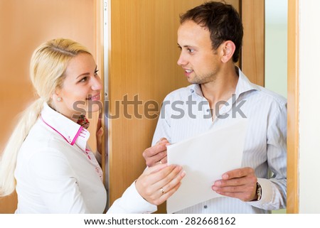 Handsome young guy conducting  survey among people at door