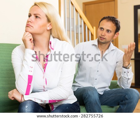 Family quarrel. Young man and sad woman during quarrel at home