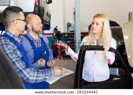 Young blonde woman duping by troubleshooters at auto service center