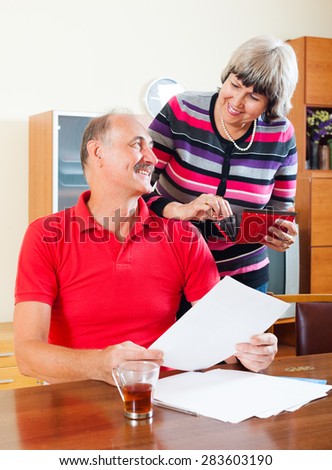 Happy mature family  with financial documents at home interior