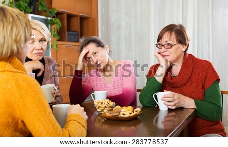 sad senior  friends drinking coffee and sharing problems