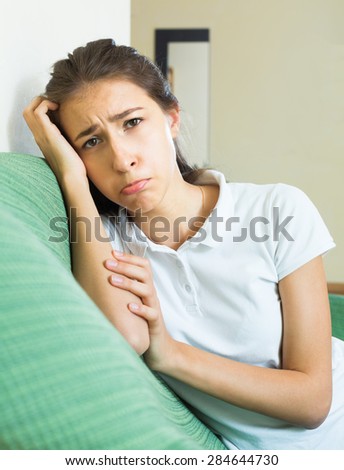 Portrait of upset alone sad girl suffering from troubles in home