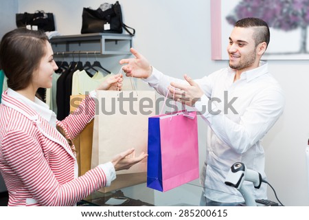 Smiling customer paying for new apparel at store counter