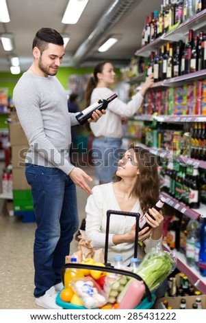 Married couple buying wine and beer in a supermarket