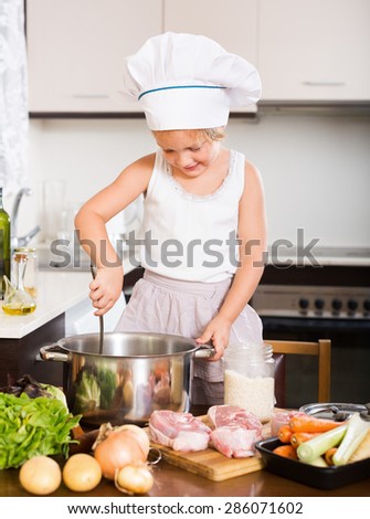 Funny  girl cooking food at domestic kitchen