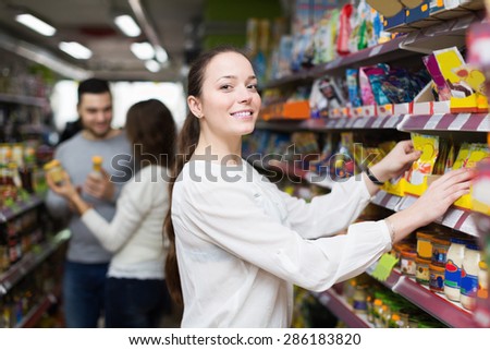 Happy adults choosing tinned food at supermarket