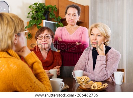 sad senior female friends  problems at table