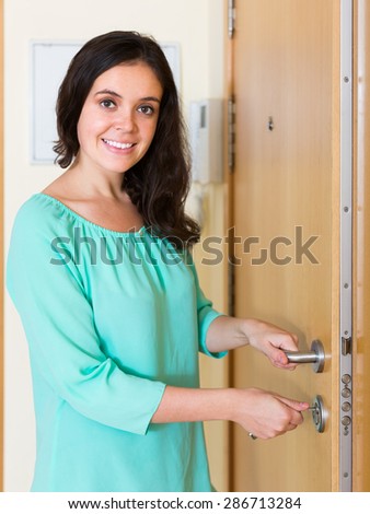 Smiling housewife trying new lock of front door