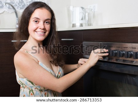 Happy woman with cooked food in home kitchen