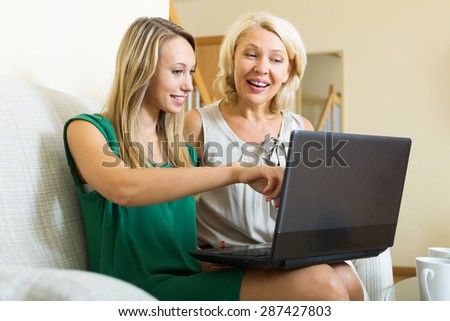 Happy daughter teaching mother to computer literacy