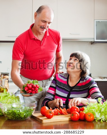 Senior man and mature woman  cooking vegetables lunch in home