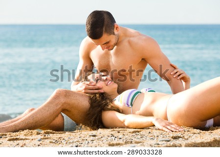 Happy woman lying on the lap of the man on the coast
