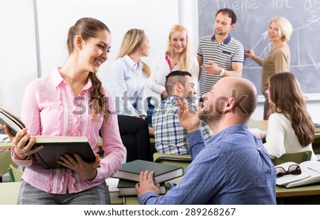 Teacher and happy adult students during break in classroom