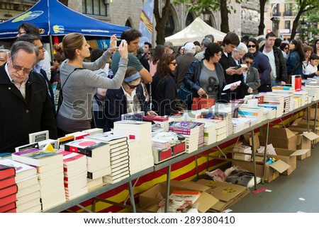 BARCELONA, SPAIN - APRIL 23, 2015:  Books on street stalls  in Barcelona, Catalonia.\
Saint George is saint patron of city, Ã¢??Ã¢??decided to give red roses and books
