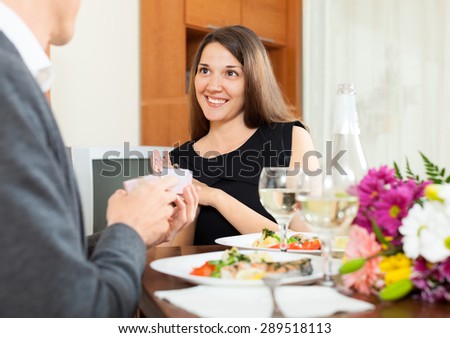 man giving a box with  ring to girl on date