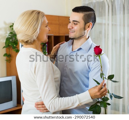 Adult son asking senior mother to dance at home