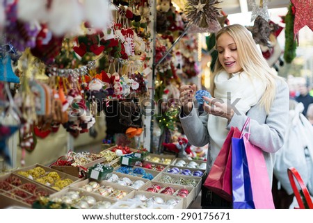 Portrait of 25s female customer  near counter with Christmas gifts