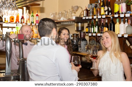 Happy bartender entertaining guests at bar counter