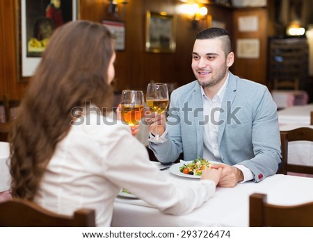 Young pretty man having romantic dinner with girl in restaurant