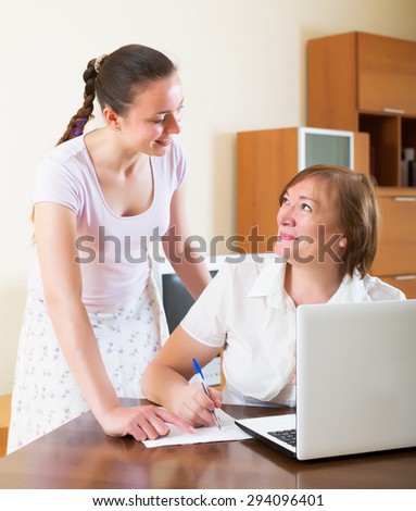Happy mature woman answer questions of social worker at home
