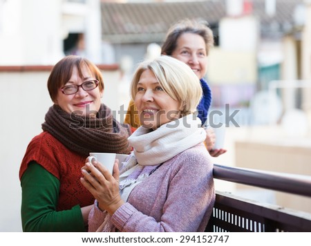 Senior female pensioners relaxing with a cup of coffee on a balcony