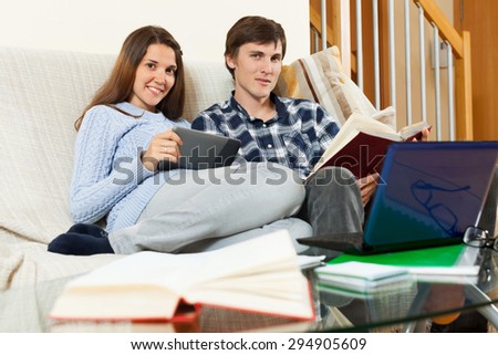 Student couple reading a book and educational materials before the exam