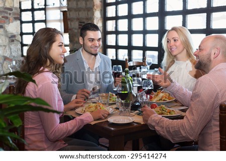 Portrait of happy adults having dinner in family restaurant