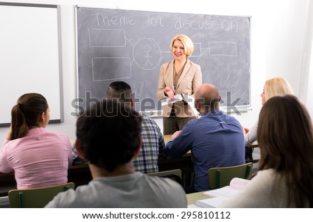 Female professor standing in front of students and lecturing them