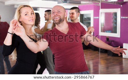 Adult couples enjoying of partner dance and smiling