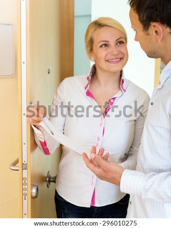 Happy woman conducting  survey among people at door