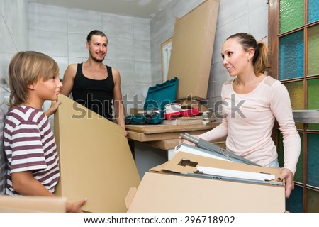 Positive friendly family of three packing things before relocation