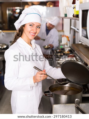 Happy  professional chefs working in restaurant kitchen