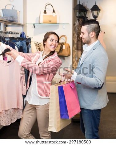 Portrait of happy young smiling couple choosing new apparel in store