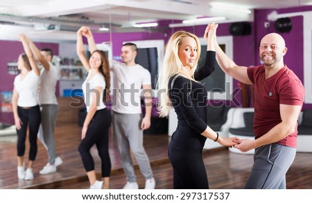Positive young couples enjoying of partner dance and smiling indoor