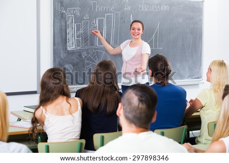 Ecxited student gives answer near blackboard during lesson