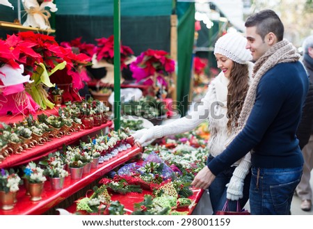 Smiling beautiful woman with her husband or boyfriend pointing at counter. Shallow focus. Focus on woman.