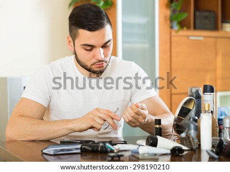 Handsome guy doing manicure at home