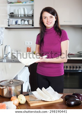 Smiling girl cooking with prepared store-bought dough at home kithen