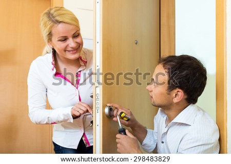 Home Repairman helps a young woman secure the home. Focus on the man