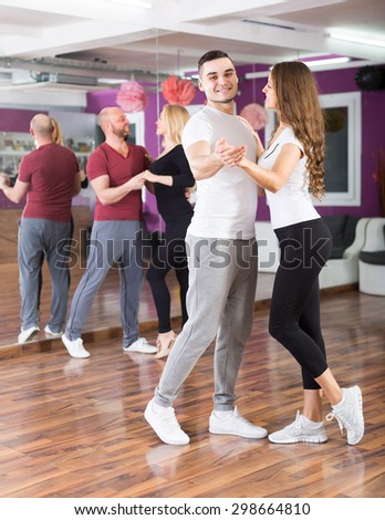 Happy young people 25-30 years old having dancing class indoors