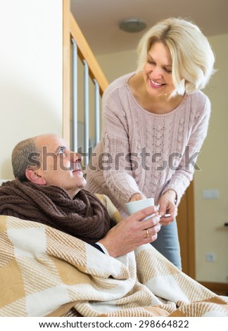 Smiling female social worker taking care of elderly man