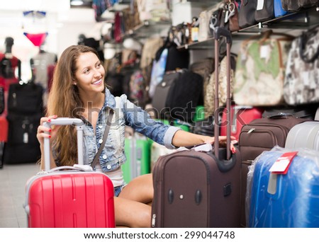 adult european  woman choosing luggage bag in shop