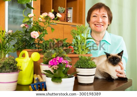 Woman with flower and cat in home