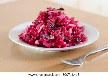Closeup of vegetable salad from stewed beet and cabbage in white plate