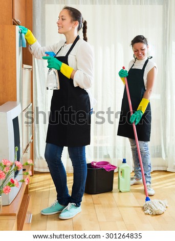 Professional cleaners washing apartment with rag and mop