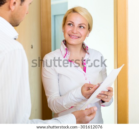 Positive young woman conducting  survey among people at door